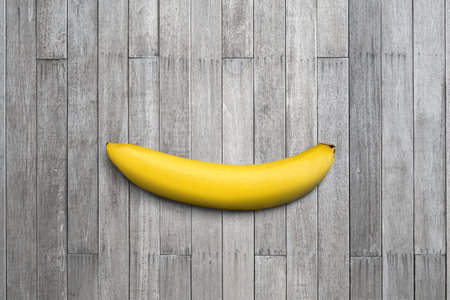 Single banana on old wooden top table.の写真素材