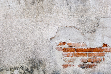 Old white concrete and orange brick wall cracked. Abstract background texture.の写真素材