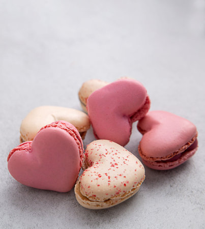 French macaroon in heart shapes on gray