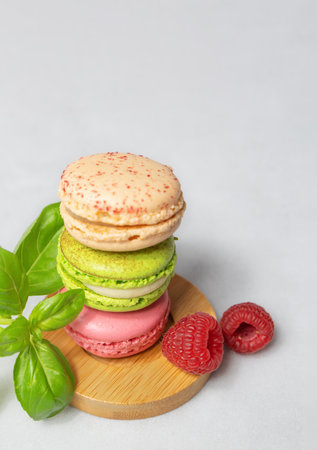 French traditional cookies - macaron, French macaroon with fruit filling on a light background with copy space. Vertical photo with confectionery.の写真素材
