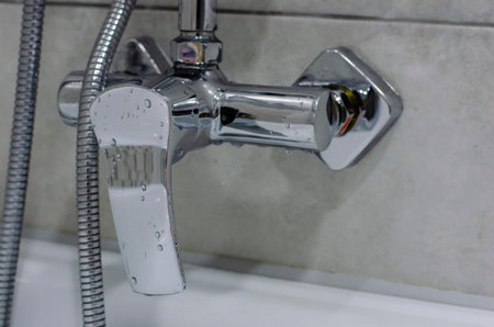 Mixer cold hot water with drops of water. Modern faucet bathroom. Kitchen tap. Chrome-plated metal.