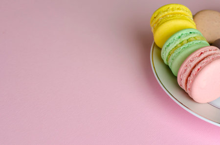 Colorful sweet french dessert macaroon or macaron on pastel pink background. Space for textの写真素材