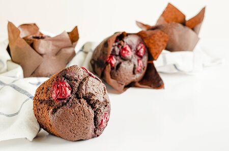 Chocolate cupcakes or muffins with cherries and powdered sugar. Close upの写真素材