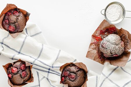 Chocolate cupcakes with cherries and powdered sugar. Overhead, copy space.の写真素材