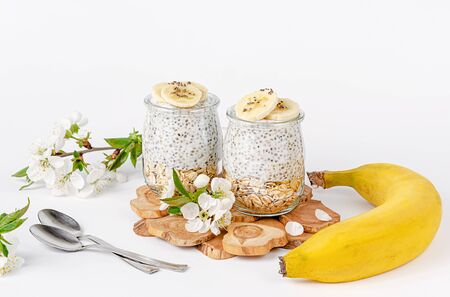 Chia pudding with yogurt, banana and oats on white background. Healthy eating concept.の写真素材
