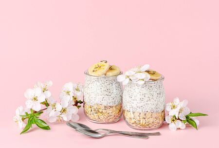 Chia seed pudding with yogurt, banana and oats on pastel pink background. Superfood concept. Copy spaceの写真素材