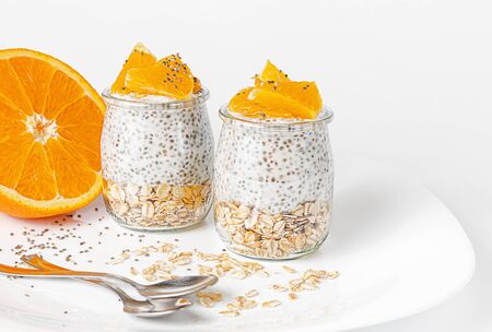 Chia seed pudding with orange and oats on white background. Superfood concept.の写真素材