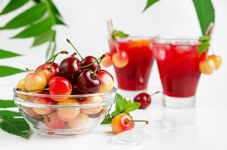 Red and yellow sweet cherries on white. Summer background