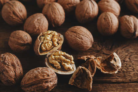 Walnut kernels in a shell on rustic wooden table. Healthy eating, close upの写真素材