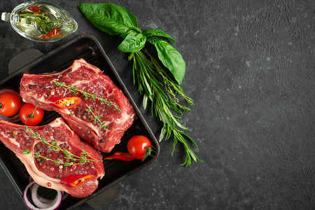 Veal bone cue ball on grill pan with vegetables,herbs and olive oil. Meat cooking. Overhead, copy...