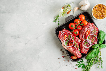 Fresh veal bone steaks on grill pan with spices and herbs on concrete background. Top view, mockup