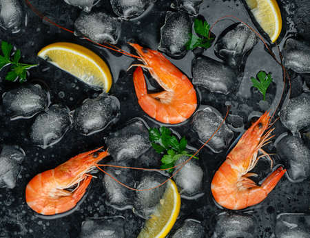 Tiger shrimps with ice, lemon and parsley. Food background. Flat layの写真素材