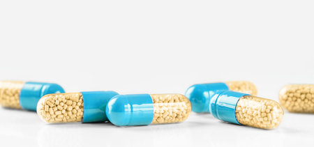 Blue capsules on white background. Copy space, painkiller concept.