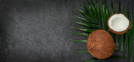 Coconuts on dark background, superfoods concept. Copy space, overhead.