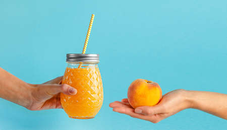 Eco friendly lifestyle and healthy food concept. Smoothie jar and peach on blue background.の写真素材