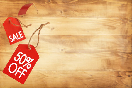 Falling sale tag of special offer on wooden background. Copy spaceの写真素材