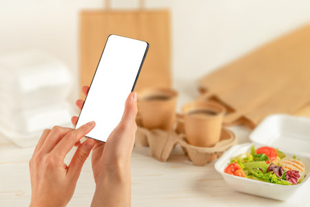 Female holding smartphone and and makes an online order. Food delivery
