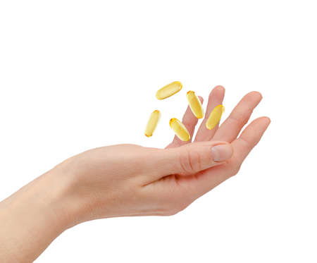 Omega 3 pills floating over female hand isolated on white background. Health care and treatment concept. high quality photoの写真素材