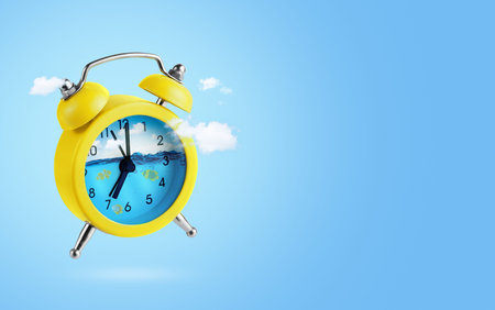 Summer vacations concept. Yellow alarm clock in clouds with underwater world inside on blue...