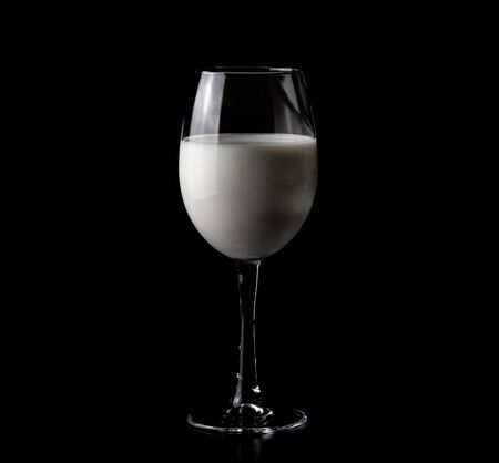 Glass of wine with milk on a black backgroundの写真素材