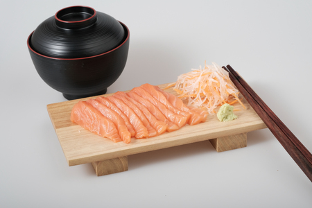 Top view raw salmon sashimi on wood board, chopsticks, and soup, Japanese traditional dish .Closed up.の写真素材