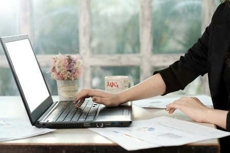 Young business women working with report paper on wooden table, vintage window in backgroundの写真素材