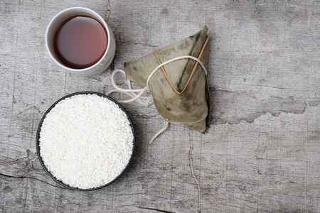 White glutinous rice  and glutinous rice dumpling or Zongzi and Chinese tea, on wooden background. close upの写真素材