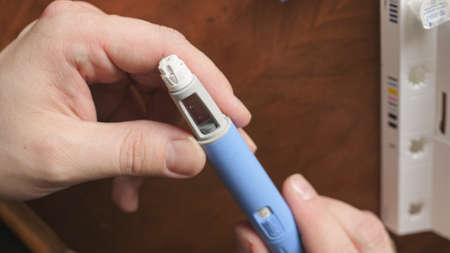 obese fat man preparing Semaglutide Ozempic injection control blood sugar levelsの写真素材