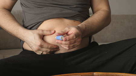 obese fat man preparing Semaglutide Ozempic injection control blood sugar levelsの写真素材