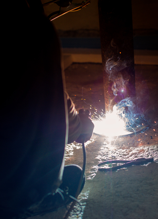 worker with protective mask welding metal, Inverter machine, welding mask,electrodes high-voltage, arc weldingの写真素材