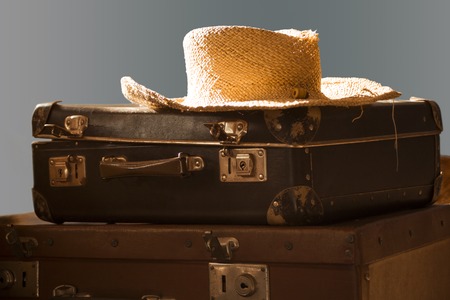 straw hat lying on old suitcasesの写真素材
