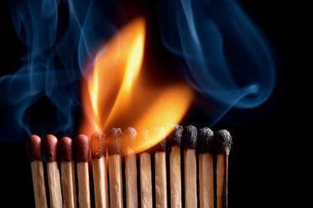 Burning matchstick on black background