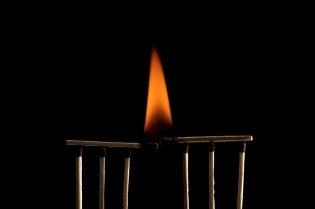 Burning matchstick on black backgroundの写真素材