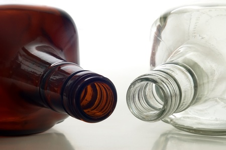 Two empty bottles lying on a white backgroundの写真素材