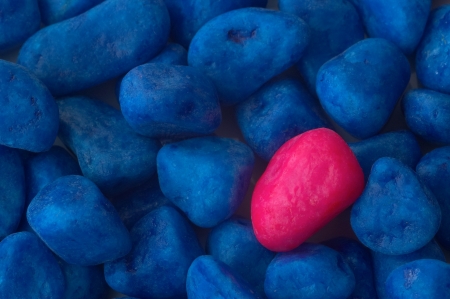 A red stone in the group of blue stoneの写真素材