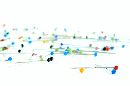Variously coloured pins on white ground 