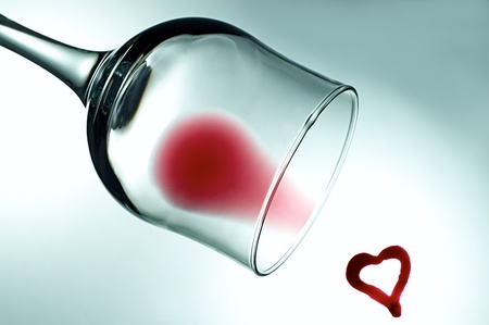 wineglass with a little red wine and heartの写真素材