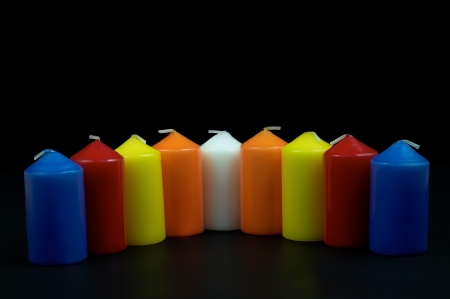 different colored candles on a black backgroundの写真素材