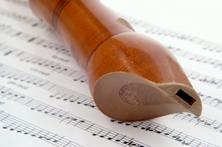 wooden flute lying on musical notationの写真素材