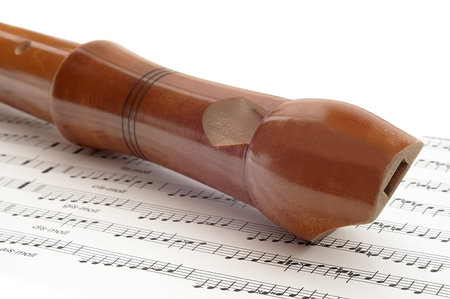 wooden flute lying on musical notation