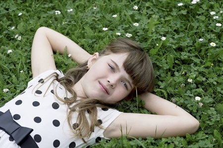 Young girl lying on her back in the grassの写真素材
