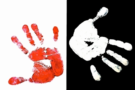 Detailed view of a red hand print on a white background and white hand on black backgroundの写真素材