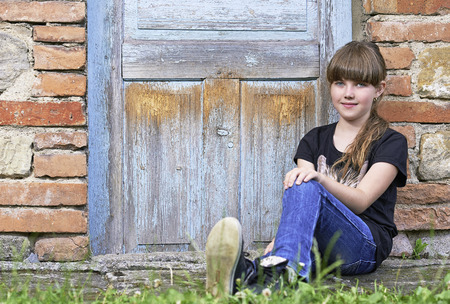 Portrait of a young girl by the stone wallの写真素材