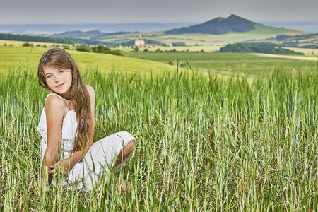 View of a young girl sitting on the grainの写真素材