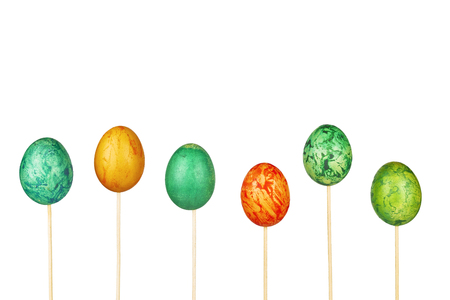 Six easter eggs on skewers with a white backgroundの写真素材