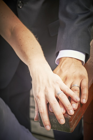 Newlyweds hands with rings on woodの写真素材