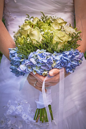 Bride holding wedding bouquet in white dress