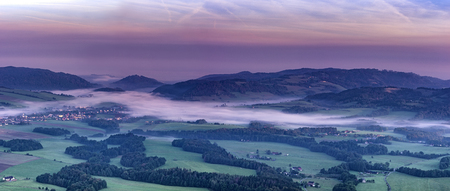 Morning panoramic view of the landscape with fog with meadows and forestsの写真素材