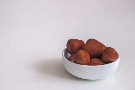 View of a group of fresh strawberries in a white bowlの写真素材
