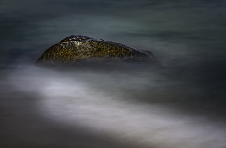 Alone stone lying on a sandy beachの写真素材